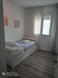 阿罗萨新镇APARTAMENTOS LA CAPILLA的白色的卧室设有床和窗户