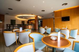 帕特纳帕特纳西班牙波萨达斯酒店的一间带桌椅和电视的餐厅