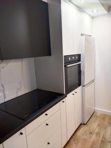 奥斯特罗文卡Apartament 11 Listopada的厨房配有白色橱柜和冰箱。