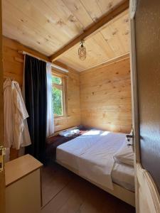 巴统Hotel Voisa/სასტუმრო ვოისა的小木屋内一间卧室,配有一张床