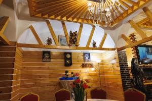 苏恰瓦Pensiunea Meteora的一间带木墙和吊灯的用餐室