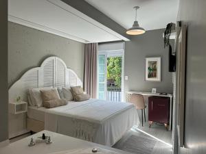 弗洛里亚诺波利斯Solar Beach Hotel的卧室配有白色的床、书桌和窗户。