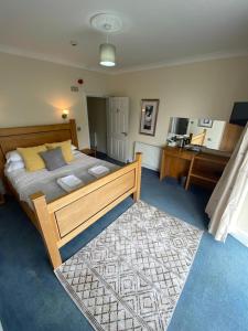 GoodwickRose and Crown的一间卧室配有一张大床和地毯。