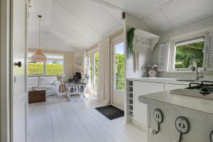 曲马勒姆Beautiful 6-person chalet with Finnish wood-fired sauna的厨房铺有白色的地板,设有窗户和桌子