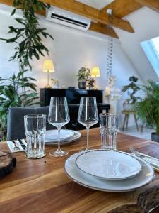布伦瑞克SKYLINE Penthouse Apartment - Luxus & Zentral的一张木桌,上面有两个盘子和玻璃杯