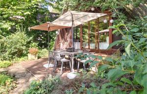 BovenwezetStunning Home In Rekem-lanaken With Wifi的露台的遮阳伞下的桌椅