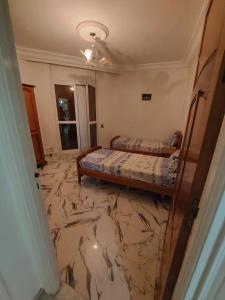 甘达坞伊港Appartement S+2 vue mer 20 mètres pieds dans l'eau的一间设有两张床的卧室,铺有大理石地板。