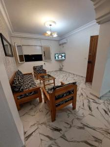 甘达坞伊港Appartement S+2 vue mer 20 mètres pieds dans l'eau的客厅配有2张桌子,铺有瓷砖地板。