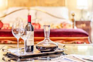 蒙泰卡蒂尼瓦尔迪切奇纳Chateau La Siroque的桌子上放有一瓶葡萄酒和两杯酒