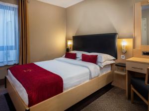 都柏林学院广场酒店的酒店客房配有一张带红色枕头的大床