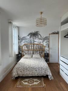 Deuil-la-BarreCharmante maison de ville proche Paris的一间卧室配有一张带棕榈树壁纸的大床