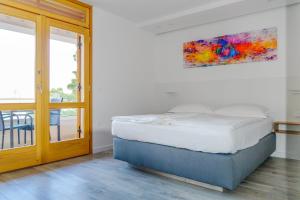 布雷拉Apartment Bikin Top Floor的卧室配有一张床,墙上挂有绘画作品