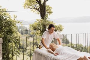 贝特纳斯科Villa Antica Colonia - Lake Orta - Suite Apartments Adults Only - SPA & Wellness的女人在床上给女人按摩