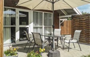奥克斯伯尔Cozy Home In Oksbl With Wifi的庭院内桌椅和遮阳伞