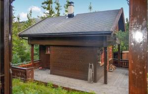 尤坎Stunning Home In Rjukan With House A Mountain View的一座带甲板和屋顶的大型棕色建筑