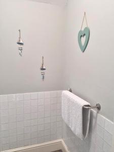 兰贝德Hafan Artro的墙上有蓝色心的白色浴室