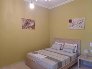 科洛皮奥Vicky's place,near Athens airport的卧室配有一张床,墙上挂有两张照片
