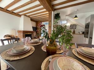 多维尔Villa normande - Les Crapauds Fous的餐桌,带盘子和花瓶