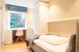 奥斯陆Cozy House的一间卧室配有一张床、一个窗口和一张书桌