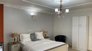 雅温得PEACE GUEST HOUSE的一间卧室配有一张床和一个吊灯