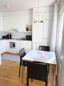 赫尔辛基PASILA Modern flat centrally located的白色的厨房配有桌椅