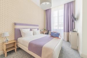科涅克厄尔塔奇酒店的一间卧室配有一张大床,上面装有蓝色袋子