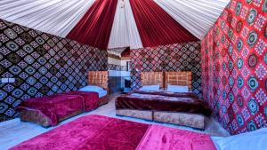瓦迪拉姆WhyDesert Camp & Tours的一间设有两张床和帐篷的房间