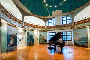 劳特拉赫劳特拉施宫酒店的一间设有钢琴和壁画的房间