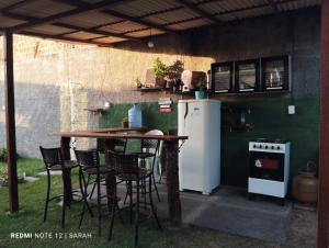 巴雷里尼亚斯Temporada Casa dos Paiva的户外厨房配有桌椅和冰箱。