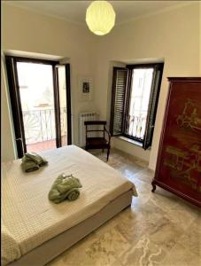 菲乌吉Casa Vittorio Emanuele的一间卧室配有一张带两张绿毛巾的床