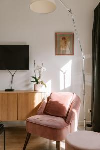 赫林贝亨BnB Manere的客厅配有椅子、电视和灯具