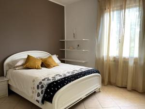 佩萨罗Casa Isore con 3 camere da letto的卧室配有白色床、黄色枕头和窗户