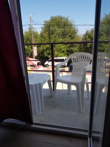 科斯蒂内什蒂EVANA HOUSE的阳台配有2把白色椅子和桌子