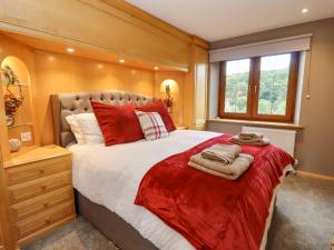 切尔滕纳姆Manor Farm的一间卧室配有一张带红色枕头的大床