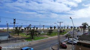 伊基克Hotel La Carreta Playa Brava的一条城市街道,海滩上停有汽车