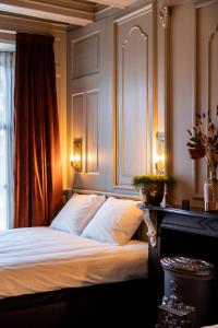 吕伐登De Olde Signorie的一间卧室配有一张带白色床单的床和一扇窗户。