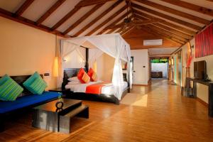 Meedhoo马尔代夫卡娜丽度假村的一间卧室配有一张床和一个沙发