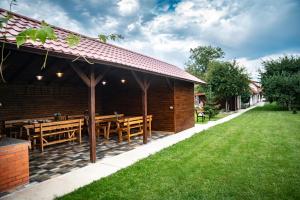 克尔茨什瓦拉乡Magda Garden的一间带木桌和绿色草坪的餐厅