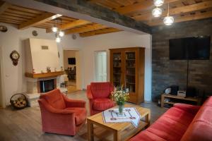克尔茨什瓦拉乡Magda Garden的客厅配有红色家具和壁炉