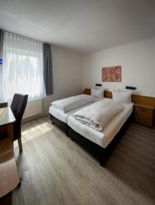 埃森施密特加尼酒店的一间卧室配有一张床、一张书桌和一个窗户。