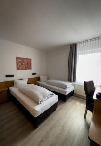 埃森施密特加尼酒店的酒店客房设有两张床和窗户。