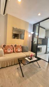 芭堤雅市中心The base Central Pattaya 903 by Numam的客厅配有一张沙发,上面有两只泰迪熊