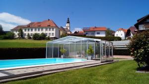 Wenigzell豪斯玫瑰宾馆的院子中游泳池周围的温室