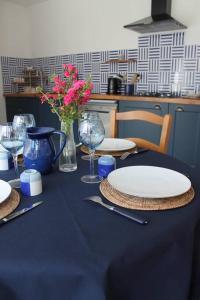 萨尔特河畔弗莱斯涅Maison rénovée Atoué loc的一张带盘子和玻璃杯的蓝色桌子