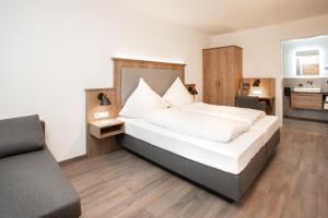 菲尔斯比堡Landgasthof Maier的一间卧室配有一张床和一张沙发