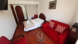 查查波亚斯Casa Kuelap Hostal的一间卧室配有一张床和一张红色的沙发