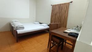 西里古里Hotel Saluja的小房间设有一张床和一张桌子