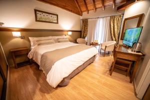 拉安戈斯图拉镇Resort de montaña - La Comarca的一间卧室配有一张床、一张书桌和一台电视