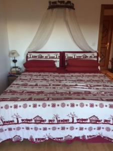 克莱恩 蒙塔纳La casetta di Crans的一间卧室配有一张带红色和白色床罩的床。