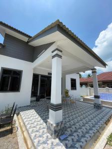 Kota BharuHomestay PCB Villa MamaKaya的白色的房子,在庭院设有凉亭